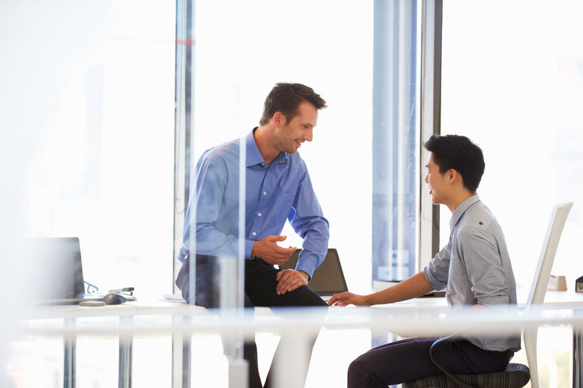 Three Factors for Better Communication in Mentoring 6 A mentor and mentee talking in a modern office.