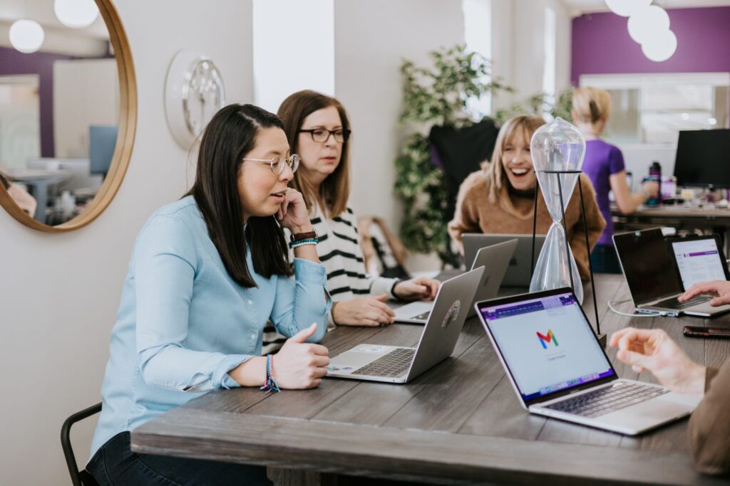 What Is DEIB? Defining Diversity, Equity, Inclusion, and Belonging 4 Three women in an office talking and exploring the concept of "what is deib?"