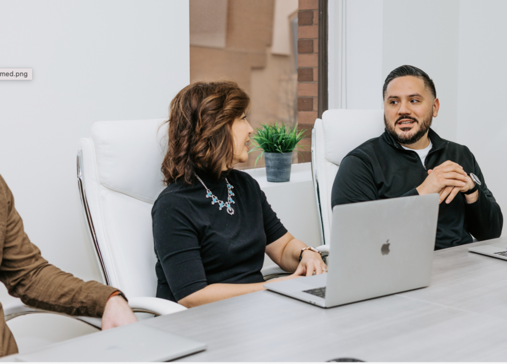 How a Diverse Workplace Can Drive Innovation (Research-Backed) 5 Two employees sitting in an diverse workplace setting having a conversation.