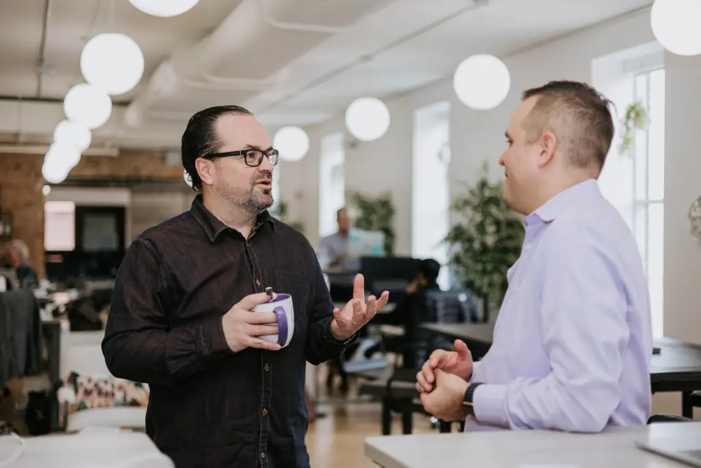 What Is Succession Planning? Key Definition and Strategies 7 Two men in an office discussion learning agility in succession planning.