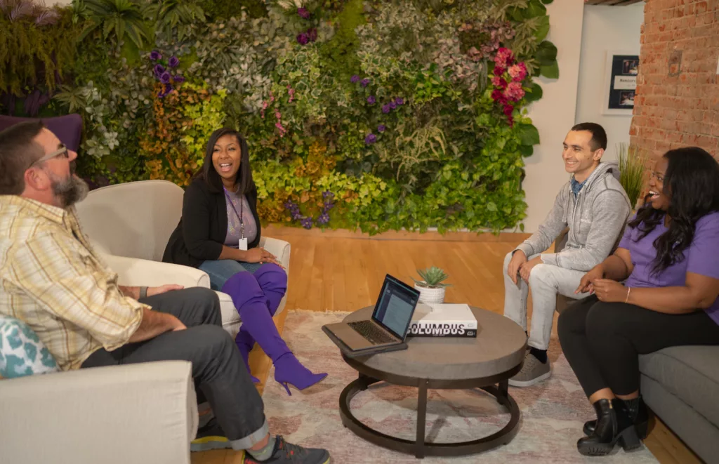 10 Unconscious Bias Examples (And How to Avoid Bias in Your Workplace) 7 4 team members from Mentorcliq meeting up around a coffee table to discuss mentoring ideas.