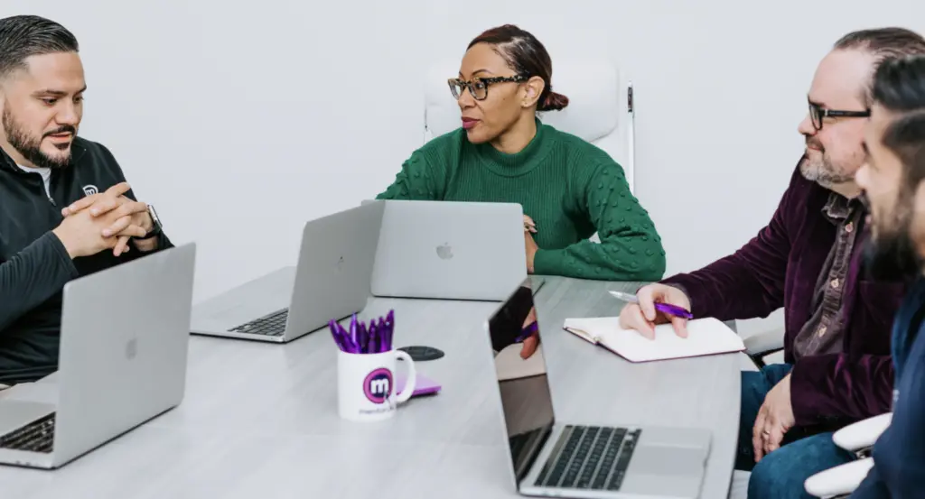 How to Be an Ally to an ERG 5 Image of individuals in an office discussing how to be an ally.