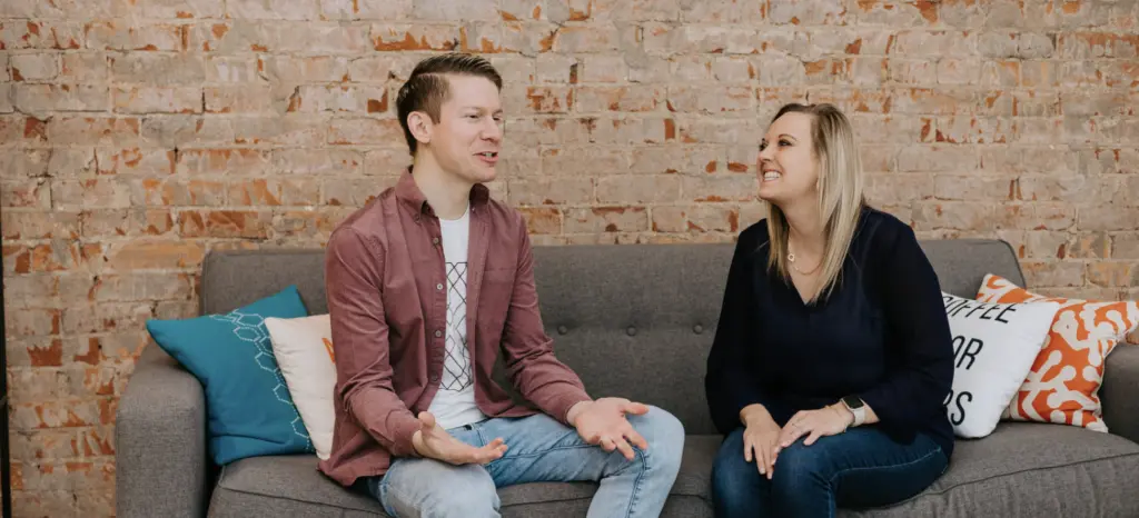 What Is an Employee Value Proposition? 6 An image of employees happily in the workplace on a couch chatting.