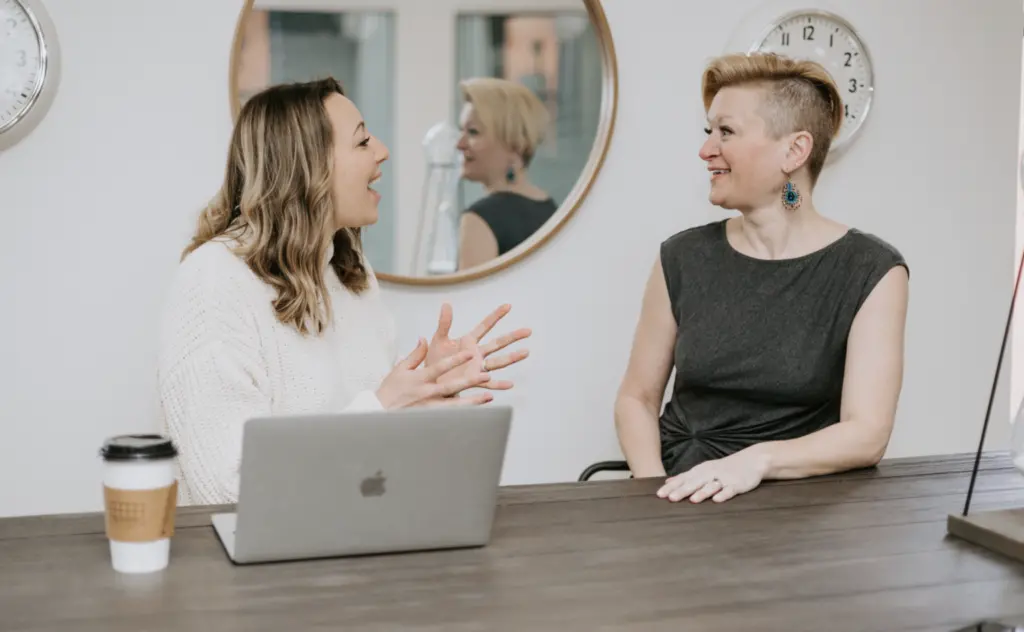 What Is DEIB? Defining Diversity, Equity, Inclusion, and Belonging 5 Two women sitting at a table in an office in deep discussion.